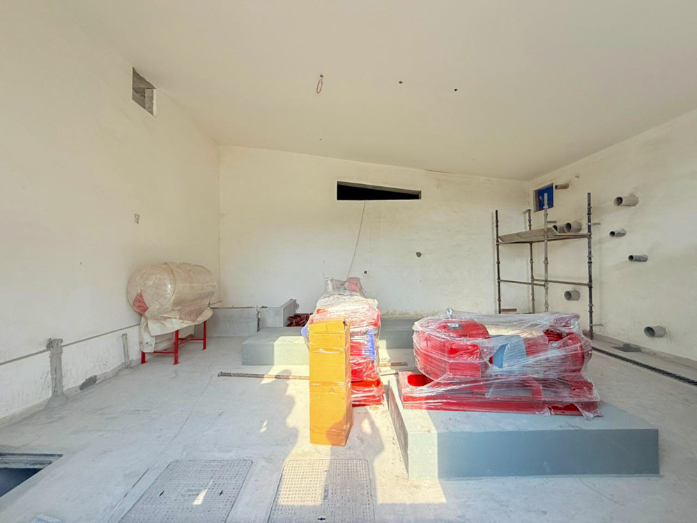 Beach Walk Iii By Imtiaz An unfinished room with white walls, construction materials wrapped in plastic, and a scaffolding setup visible.